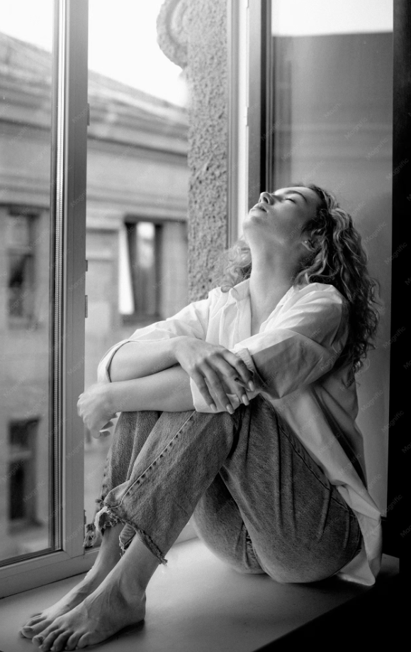 Woman reflecting by a window, representing attachment styles at work